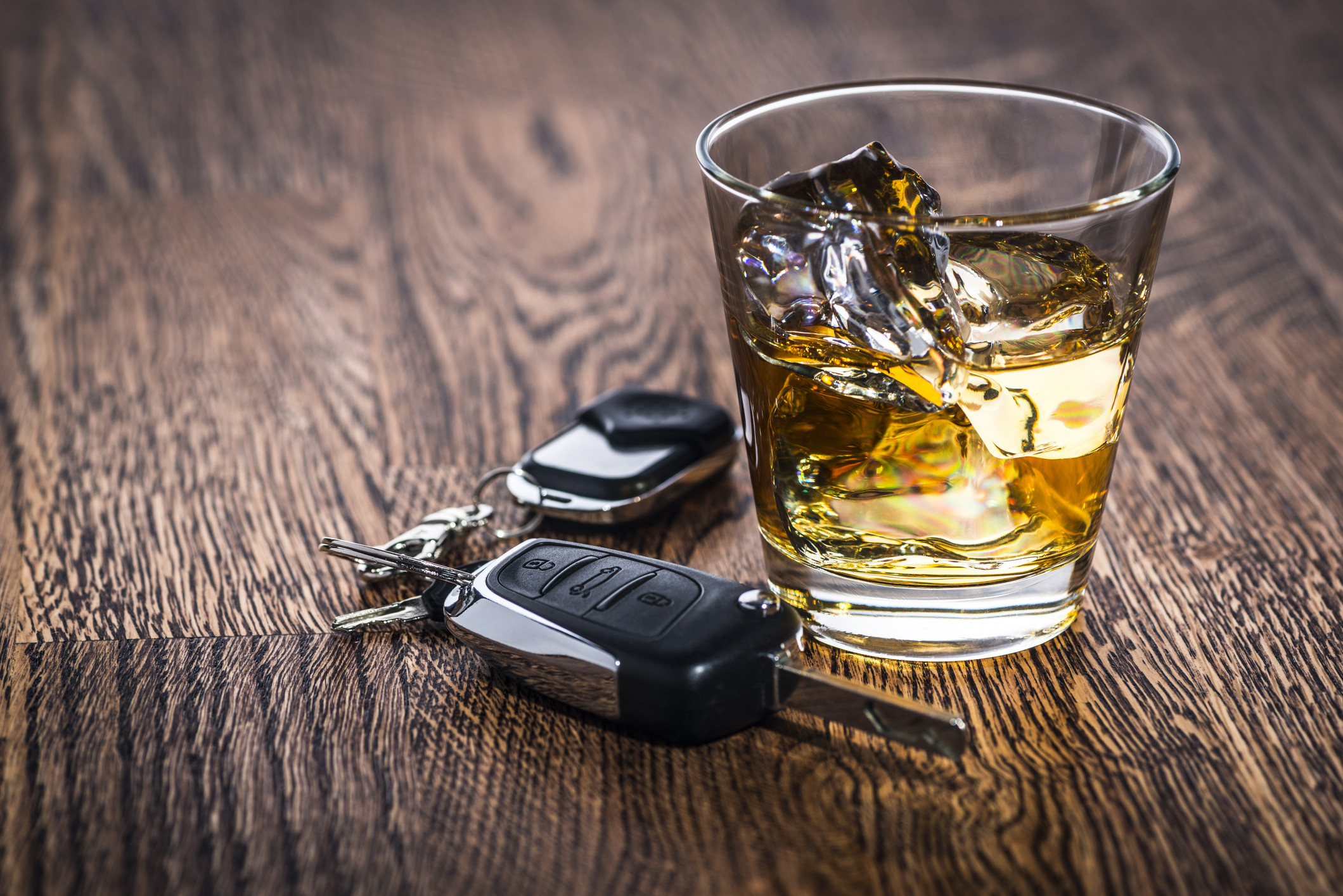 A glass of liquor next to car keys on a table symbolizing drunk driving accidents