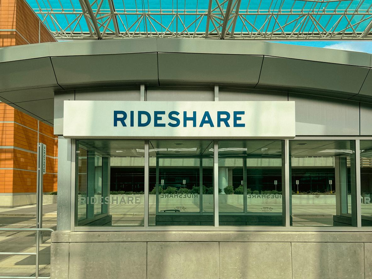 The rideshare pick-up area at an airport with a sign labeled Rideshare