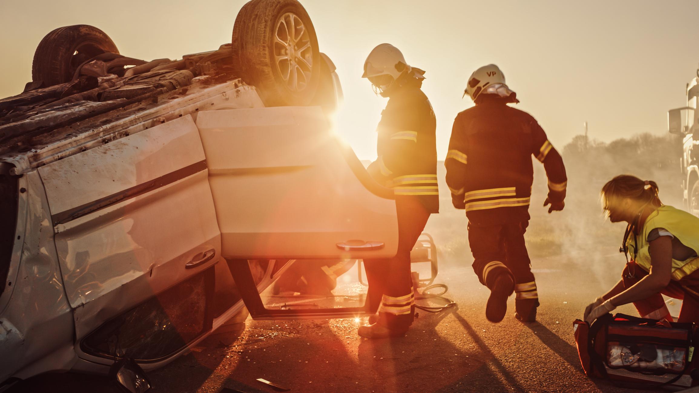 First responders helping to pull someone from a rollover car accident