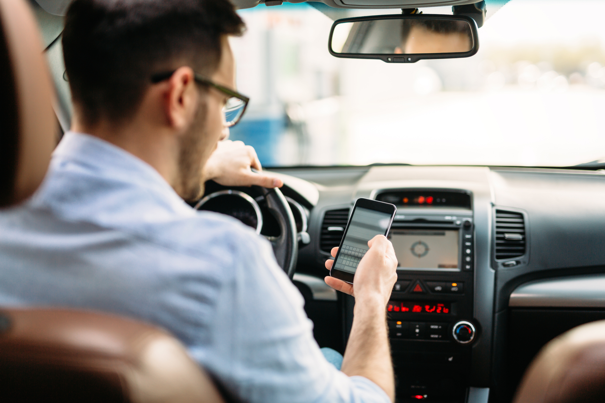 A distracted driver looking at their cellphone while driving
