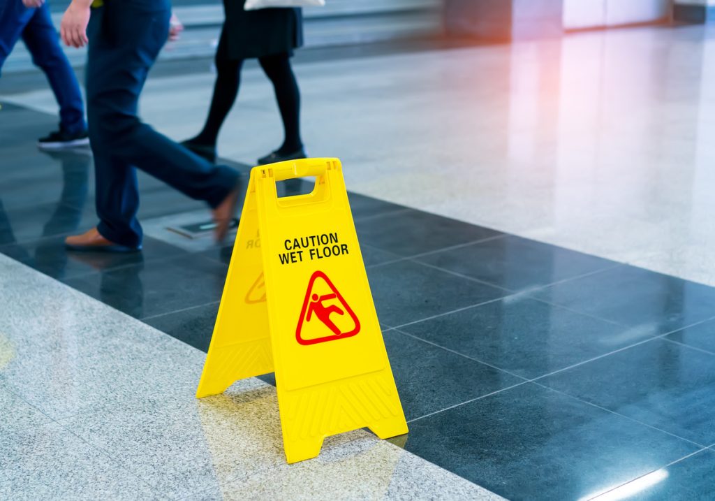 A yellow caution: wet floor sign on a wet floor